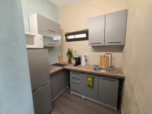 a small kitchen with a sink and a microwave at Villa Topaz in Capoterra