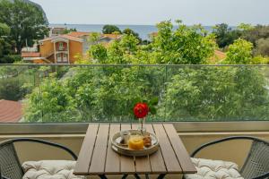 a table with a vase of flowers on a balcony at Apartments Via Mare in Petrovac na Moru