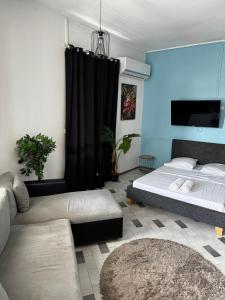 a living room with a bed and a couch at Urban Zen Appart Spacieux studio atypique avec bain a remous proche de tout in Pointe-à-Pitre