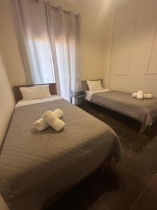 two beds with towels on them in a room at Natalie’s House in Alexandroupoli