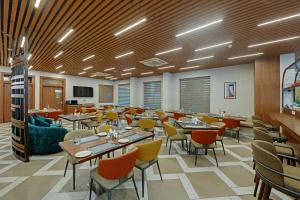 a large dining room with tables and chairs at Click Collection Aster, Raja Park - Jaipur in Jaipur