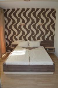 een bed in een kamer met een muur bij Eos Hotel in Vidin