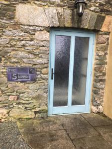 a door to a stone building with a sign on it at The Shippon at RoseHip in Launceston