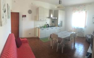 a kitchen and dining room with a table and a red couch at Casa Vacanze Elisa in Manciano