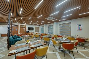 a large dining room with tables and chairs at Click Collection Aster, Raja Park - Jaipur in Jaipur +18 photos