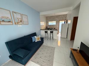 a living room with a blue couch and a kitchen at Mar Azul Beach House in Cabo Frio