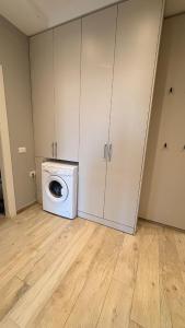 a laundry room with a washing machine and cabinets at Apartment in Golem in Golem
