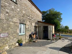a building with two bikes parked outside of it at The Shippon at RoseHip in Launceston +4 photos