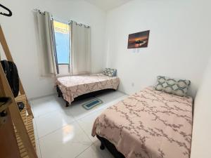 a bedroom with two beds and a window at Mar Azul Beach House in Cabo Frio