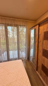 a bedroom with a bed and large windows and a bed sqor at Sun Estate Ureki in Ureki
