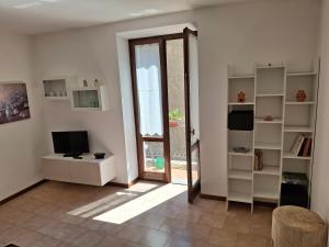 a living room with a door and a television and a window at Appartamento Felis in Molina di Ledro