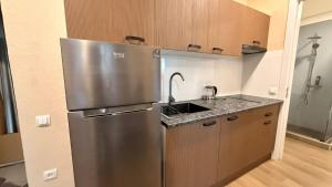 a kitchen with a stainless steel refrigerator and a sink at Sun Estate Ureki in Ureki
