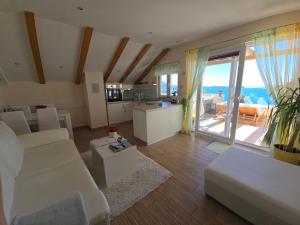 a living room with white furniture and a view of the ocean at Casa Milolaza in Mlini