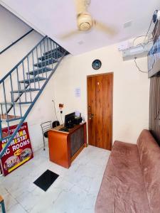a living room with a desk and a staircase at Nirvana Homestay in Mathura