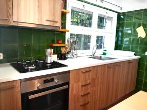 a kitchen with wooden cabinets and a stove and a sink at Casa Flor de Taronger in Viladecáns