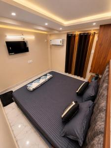 a large bed in a room with a flat screen tv at Nirvana Homestay in Mathura