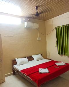 a bedroom with a bed with a red blanket at Caffe Bombay in Nagaon +2 photos