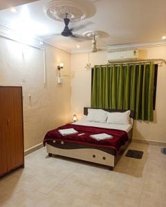 a bedroom with a bed with a green curtain at Caffe Bombay in Nagaon