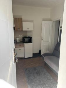 a small apartment with a kitchen and a couch at Novosadska Tvrdjava Apartments in Petrovaradin