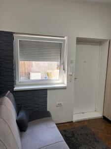 a living room with a couch and a window at Novosadska Tvrdjava Apartments in Petrovaradin +1 photo