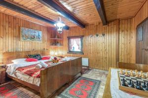 a bedroom with a bed in a wooden room at Chalet Birchwood With Hot Tub and Sauna - Happy Rentals in Hum Breznički