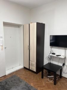 a room with a tv and a desk and a cabinet at Novosadska Tvrdjava Apartments in Petrovaradin
