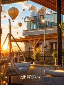 a picture of a building with a horse and balloons at Cappadocia Pegasos Cave Suite Hotel in Uçhisar