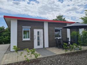a small house with a table and an umbrella at Campingpark Rammingen in Rammingen