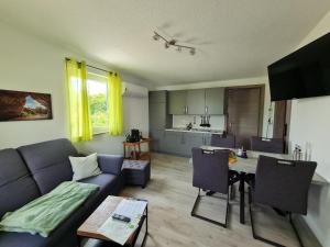 a living room with a blue couch and a table at Campingpark Rammingen in Rammingen