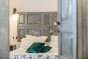 a bed with a wooden headboard and two green pillows at Dimora Ferraris in Càbras