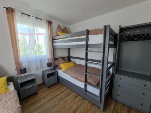 a bedroom with two bunk beds and a window at Campingpark Rammingen in Rammingen