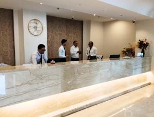 a group of men standing at a reception counter at Hotel Maamoun in Gafsa