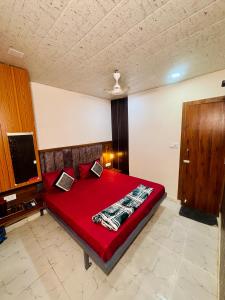 a bedroom with a red bed with two laptops on it at Nirvana Homestay in Mathura +10 photos