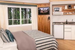 a small bedroom with a bed and a kitchen at Miradores del Bosque Apart & Spa in Mar de las Pampas