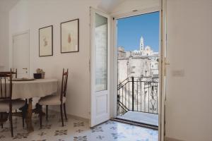 a room with a table and a glass door with a view at 360 view of the Sassi in Matera