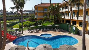 an overhead view of a swimming pool with chairs and umbrellas at Apartamentos Atlántico Resort in Montalvo