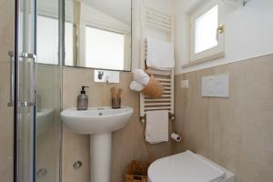 a bathroom with a sink and a toilet and a mirror at 360 view of the Sassi in Matera