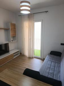 a living room with a bed and a television at APARTAMENTOS MATARRANYA in Valderrobres