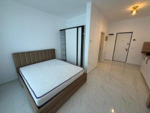 a bedroom with a bed with white sheets on it at Ayan Studio - Băile Felix in Sînmartin