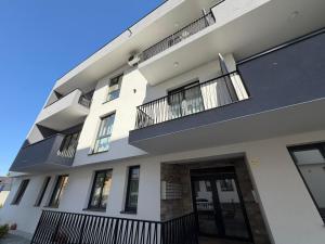 a white building with black balconies on it at Ayan Studio - Băile Felix in Sînmartin
