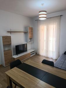 a living room with a table and a couch and a television at APARTAMENTOS MATARRANYA in Valderrobres