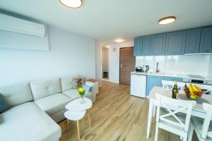 a living room and kitchen with a couch and a table at Skyline Apartments - Sea View, Pools, SPA&Free Parking in Varna City