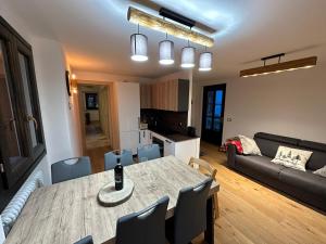 a kitchen and living room with a table and chairs at SnowLodge Valmalenco in Caspoggio
