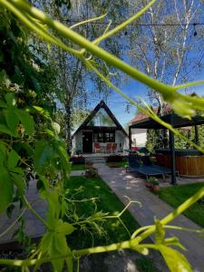 a house with a pavilion in a garden at LODKA Vendégház in Szigetcsép
