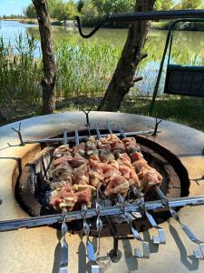 a bunch of meat cooking on a grill at LODKA Vendégház in Szigetcsép