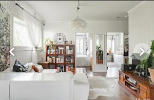 a living room with a white couch and a book shelf at Tina's Apartment in Pori