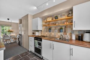 a kitchen with white cabinets and a sink at Castleview in Hillsborough