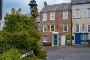 an old brick building with blue doors and a street sign at Castleview in Hillsborough