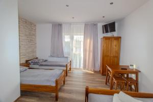 a room with three beds and a table and a desk at DW u Rafała i Joanny in Białka Tatrzańska