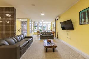 a living room with a couch and a tv at Tri Hotel Smart Santa Maria in Santa Maria